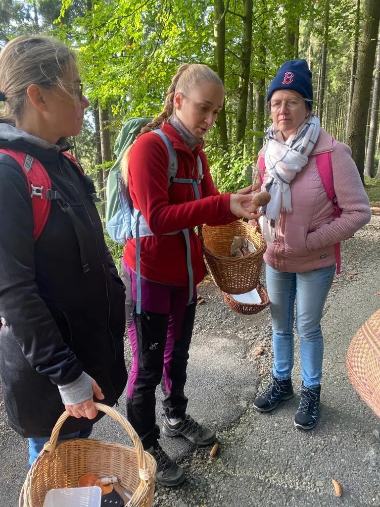 Hannah zeigt Teilnehmern Pilze bei einer Gruppentour im Soonwald
